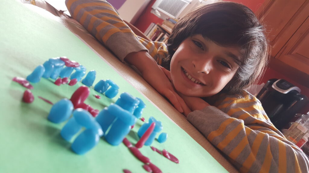 A child resting his head on the table beside colorful counting beads